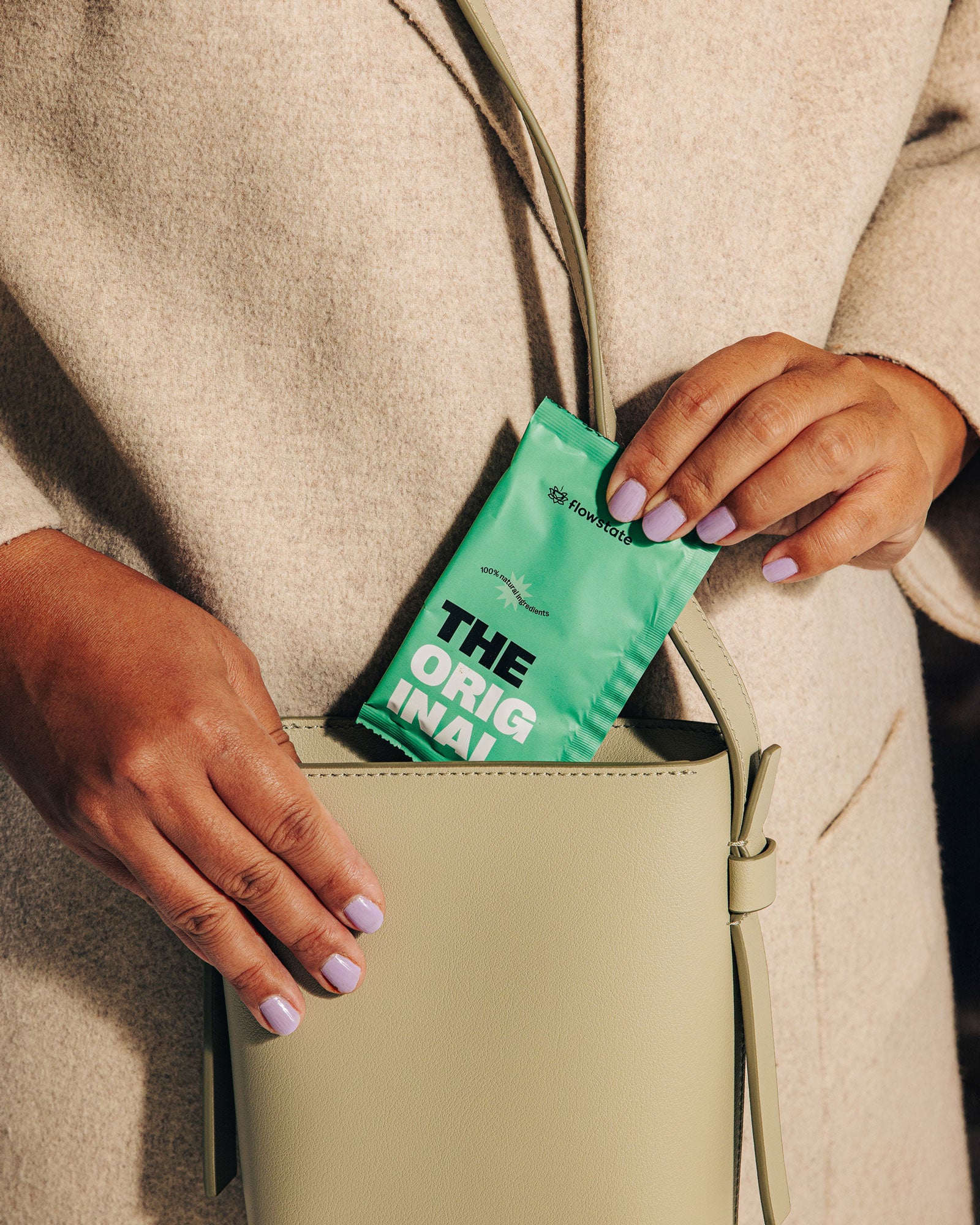 Woman putting an Original Flowstate coffee sachet into her purse